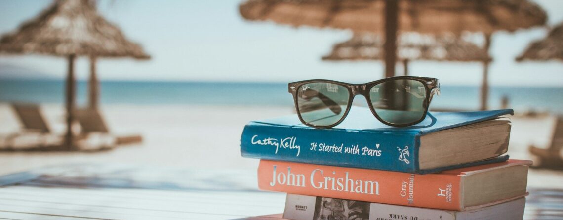black framed Ray-Ban Wayfarer sunglasses on top of book
