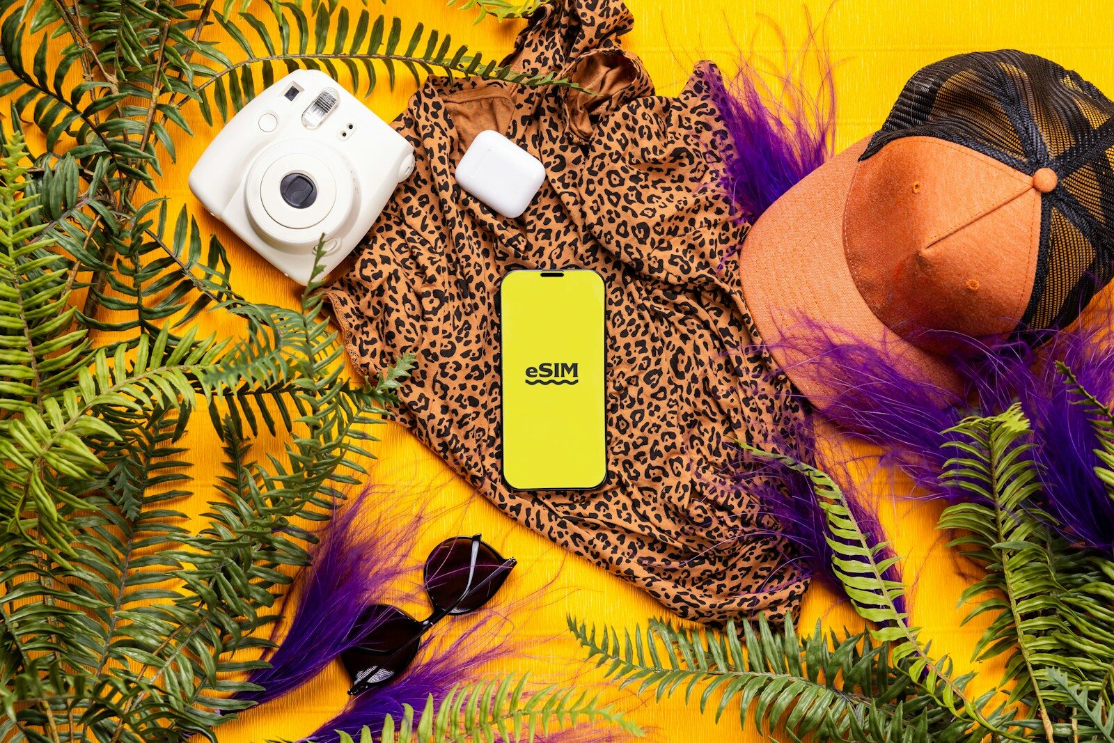 A cell phone laying on top of a lush green plant